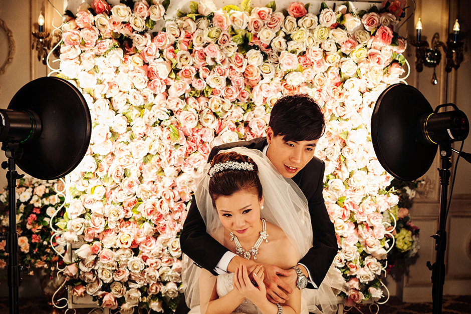 Bathed in a photographer’s beauty dish lighting, Cai, thirty, embraces his wife-to-be, Tong, twenty-nine, in one of the many poses for their wedding pictures during a three-day studio session at Princess Studio, a wedding photo studio in Shanghai.
