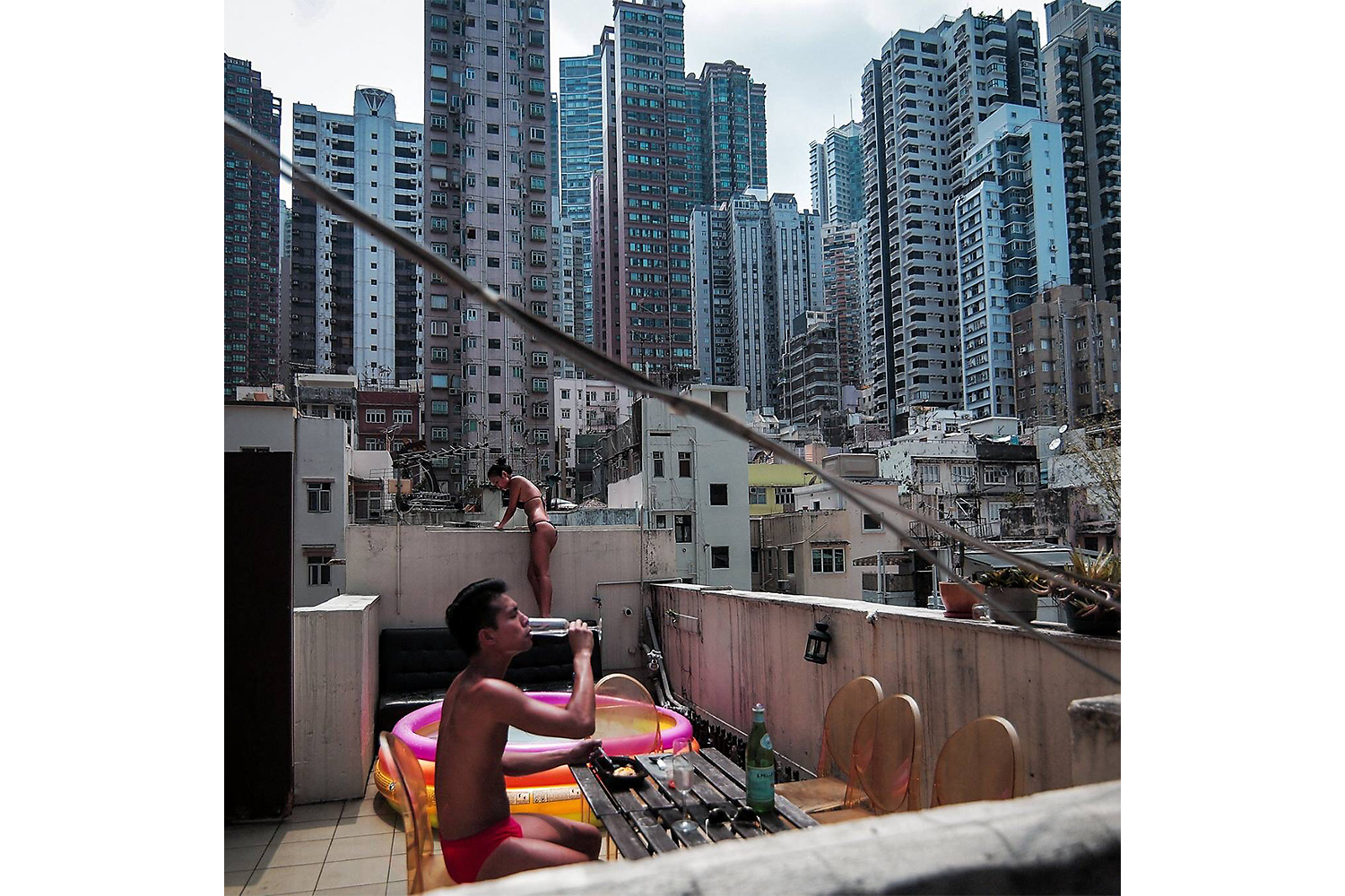 Modern apartment buildings rise in the background, as a couple soaks in the sun on the roof of one of Hong Kong’s old buildings in the city’s business district. Housing stock remains a problem in Hong Kong, where a large population lives in cramped quarters and the city’s real estate remains among the most expensive in the world. Photo by Billy H.C. Kwok @billyhckwok