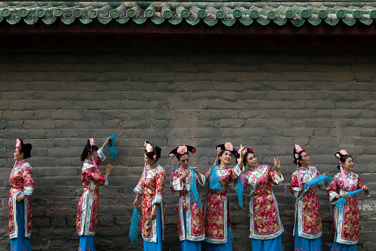 Women wearing traditional dresses stand in front of a traditional building at Ditan Park, Beijing on the summer solstice. Photo by Giulia Marchi @giuliamarchiphoto
