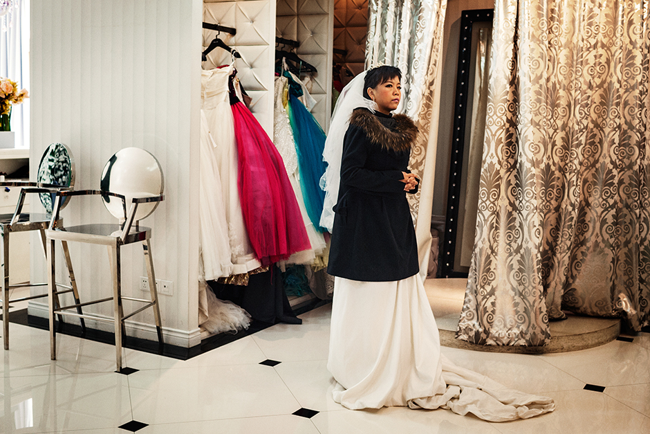 A portrait studio customer waits in a wedding dress for her session to begin at the Dream Castle photo studio.
