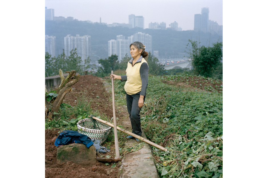 Gan Guoying, fifty-seven, a former rural <em>hukou</em> resident from Chongqing, received her urban <em>hukou</em> (residence permit) in 2006 when she renounced her 500-square-meters of land. She continues to farm here, by the side of a highway bridge, to provide for her family and to sell in the market, earning her between RMB 1,000 and 2,000 (U.S.$160-$320) for her labor. Gan says she feels the city is growing too fast for the people to adapt.