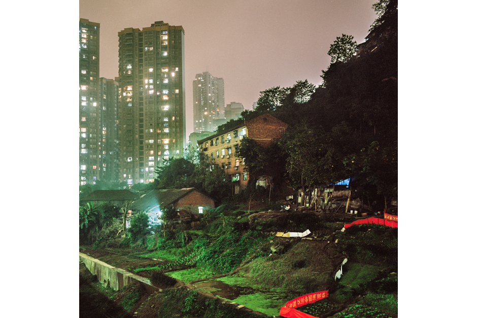 In the Shapingba district, a house and surrounding gardens are lit by urban light pollution as skyscrapers loom large from a nearby housing development project that are gaining most of the lands in this part of town.