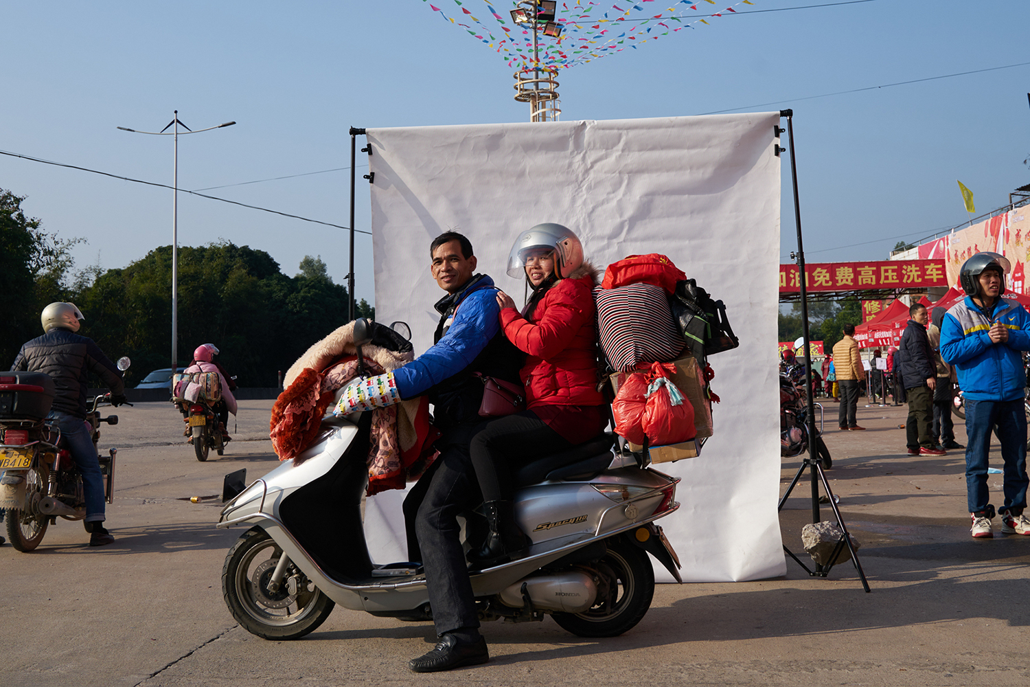 January 22, six days before the Lunar New Year, a migrant couple rides a motorcycle from Zhongshan, Guangdong province to Pingnan in Guangxi, to go home for the holiday. The trip is 245 miles. Although biking is far from the safest travel option, it’s cheap and a good way to avoid overcrowded trains and buses. (Liang Yingfei/Caixin) 