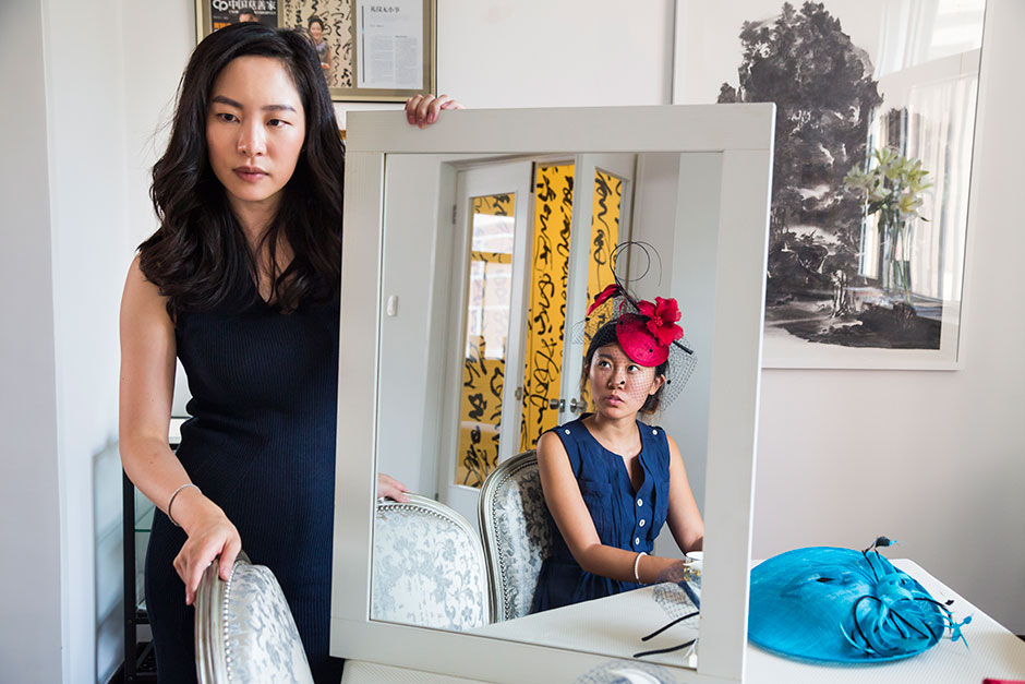 Sara Jane Ho, 29, founder of Institute Sarita, a high-end etiquette school in Beijing, a Hong Kong native who was educated at Phillips Exeter Academy, Georgetown University, Harvard Business School, and Institute Villa Pierrefeu, teaches first-time student Jessie Wen how to wear a hat.