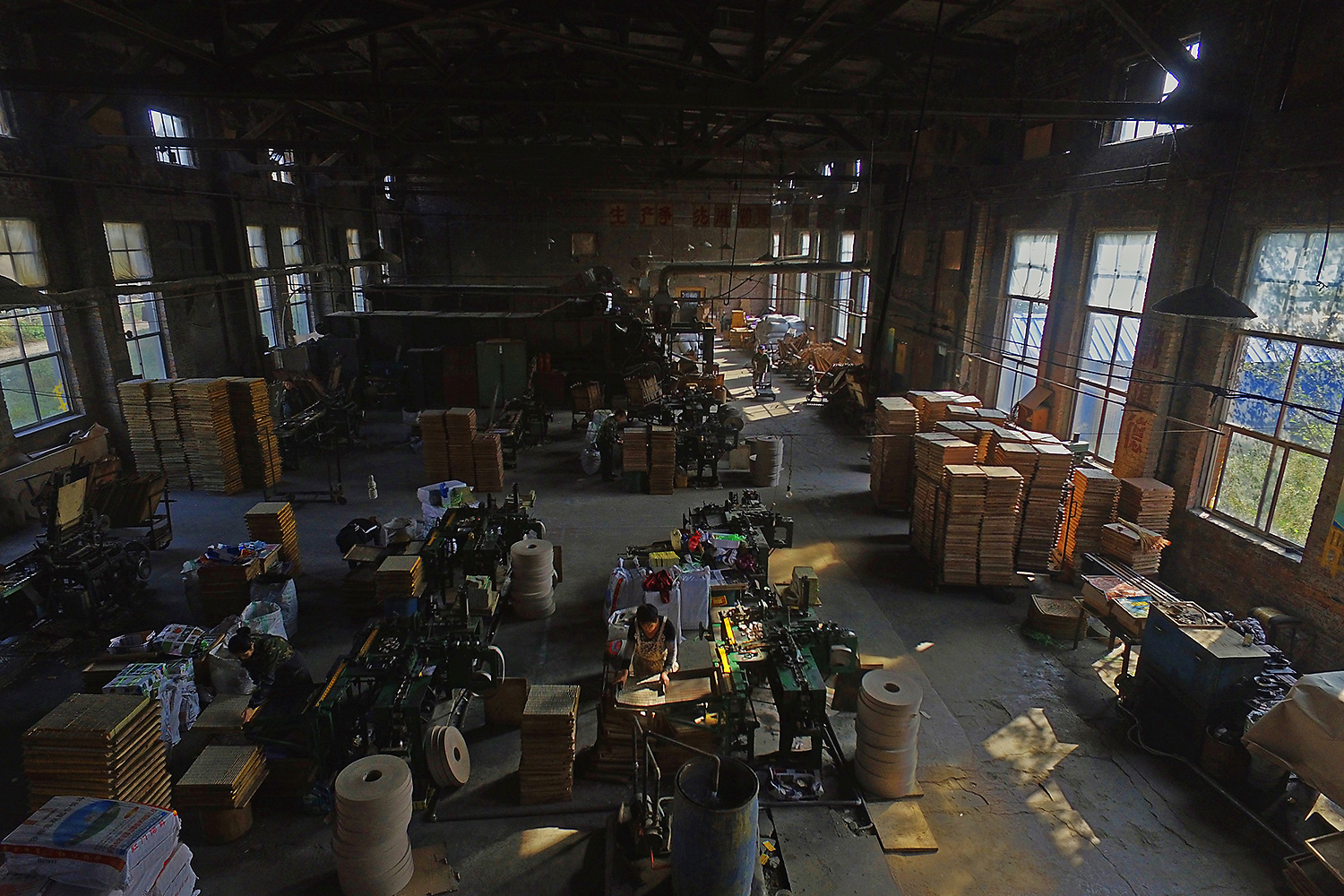 Old workshop equipment and slogans from the 1970s are still on the walls of the Yanbian factory. Workers follow long-used methods amid the thundering of machines. Here, pieces of wood are turned into thin matchsticks, and as they pass through the noisy machines, each is topped with a ‘little red cap.’ A group of workers operates the controls, and packs the finished matches into boxes.