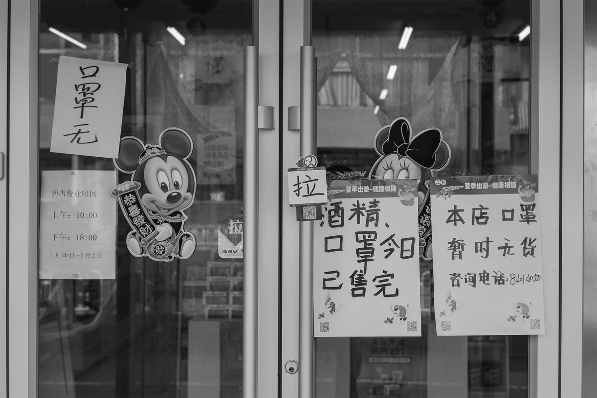 A sign reading “alcohol, masks sold out” hangs on the door of a pharmacy on Di’anmen Street, January 29, 2020.