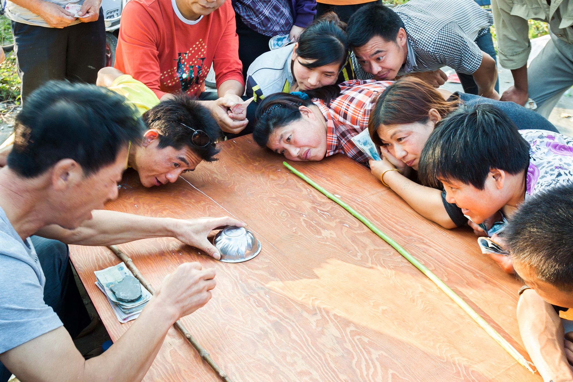 Gamblers bet cash on how many beans are in a bowl in Shencheng, October 5, 2012.