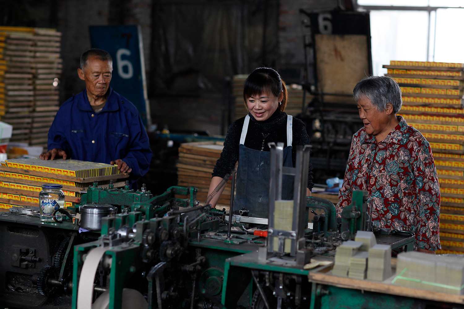 Lu’s daughter, Lu Ying, center, works at the factory as a machine operator.