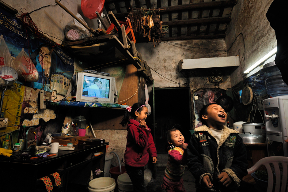 Zhao Neng, right, plays in a neighbor’s home. His parents, neither of whom got past middle school, save most of their income to send him and his older sister, Zhao Huan, to school back in more-affordable Chongqing. “Of course I want to buy an apartment,” says Zhao Xiaoyun, Neng’s dad, “but I don’t have enough money.” Instead, his parents hope that Neng will attend college.