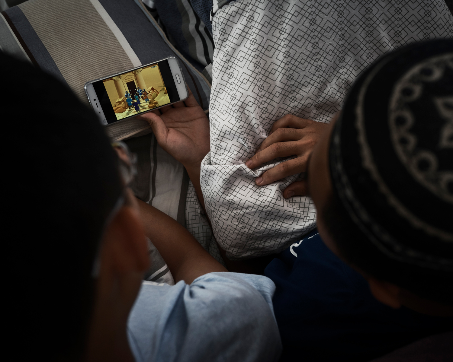 Umar and his former schoolmate watch a cartoon about the Quran at the students’ dormitory in Nanguan Mosque, June 2016.