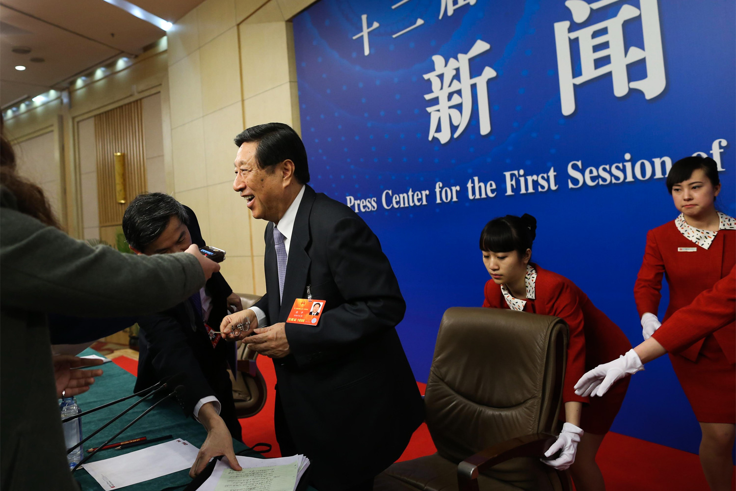 Female staff attend to Chongqing Mayor Huang Qifan during a press conference, March 4, 2011, at the Capital Hotel. Huang was close to the later disgraced Bo Xilai, who was Party Secretary of Chongqing at the time.