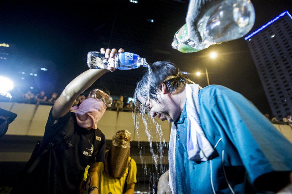 A demonstrator, suffering from tear gas exposure, is assisted by fellow protestors. (Photo by Xaume Olleros/AFP/Getty Images)