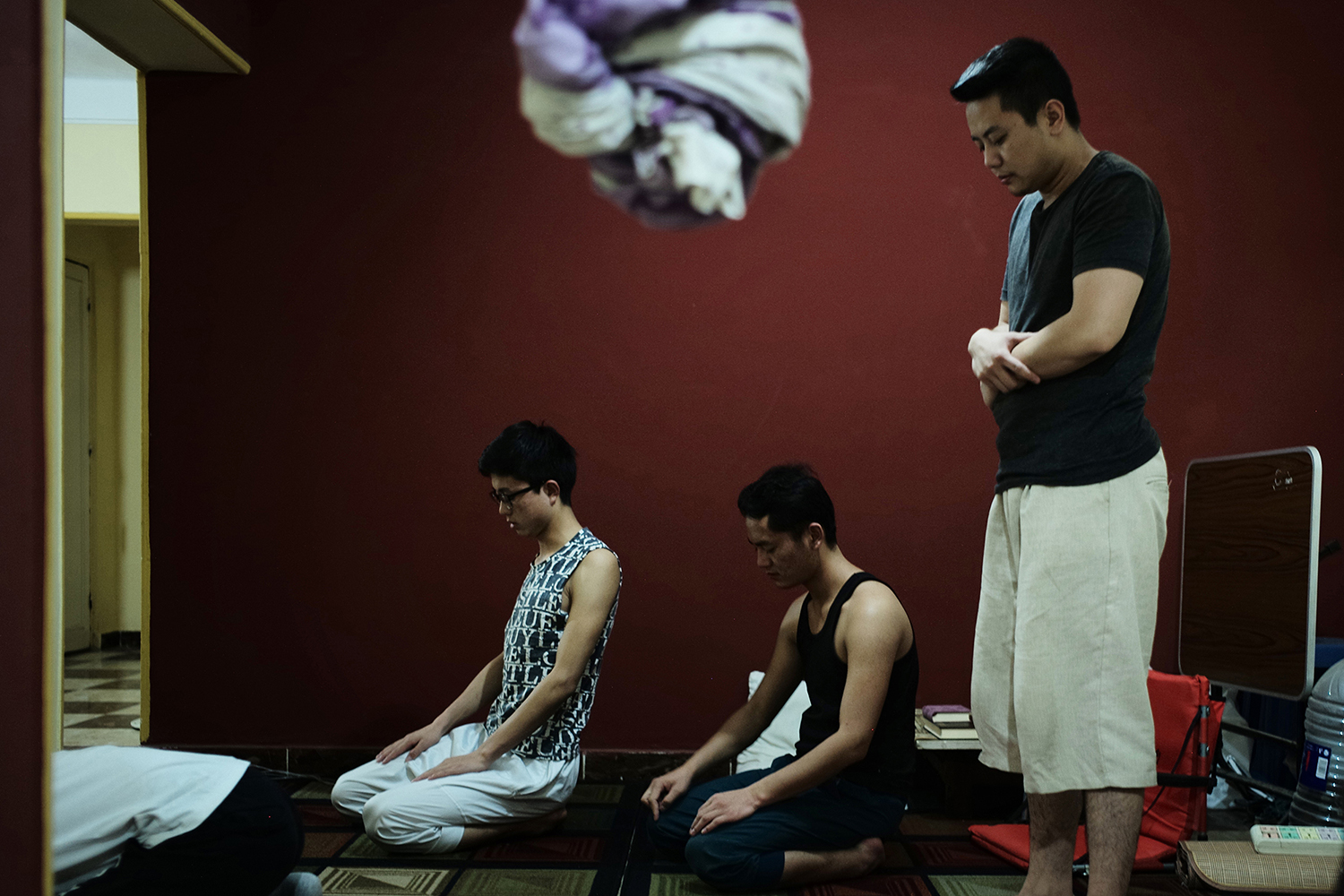May 16, 19-year-old Eid (right), a member of the Muslim Hui minority, prays with his classmates, who are also Chinese Muslims, at an apartment they rent together in Cairo, Egypt. Eid studies at Al-Azhar University in a program that prepares students for college. He rarely returns to China because he worries he might not be allowed to leave the country again. This year, China launched a campaign to repatriate and interrogate Muslims studying overseas. (Li)