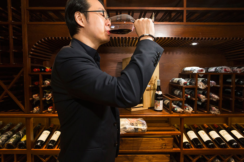 Architect Jeffrey Zee, a member and designer of A.S.C. Fine Wines’ “Wine Residence” in Shanghai, drinks red wine in his private cellar.