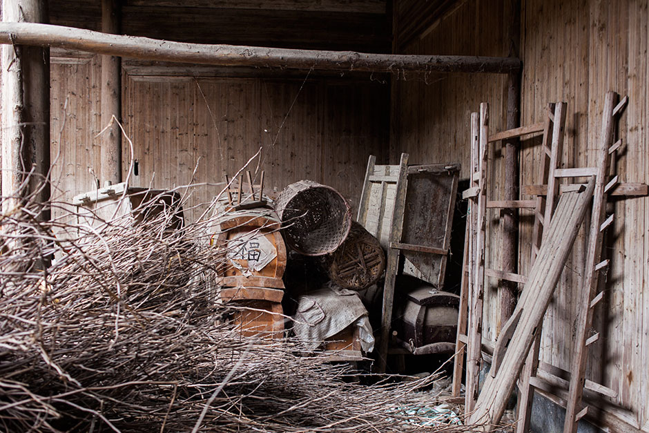 Renovation is still a distant goal for Mingxian Hall, where brush and lumber obscure a stack of coffins. In Huizhou, locals consider it auspicious to pre-order custom-made coffins in mid-life. Many of them are stored here.