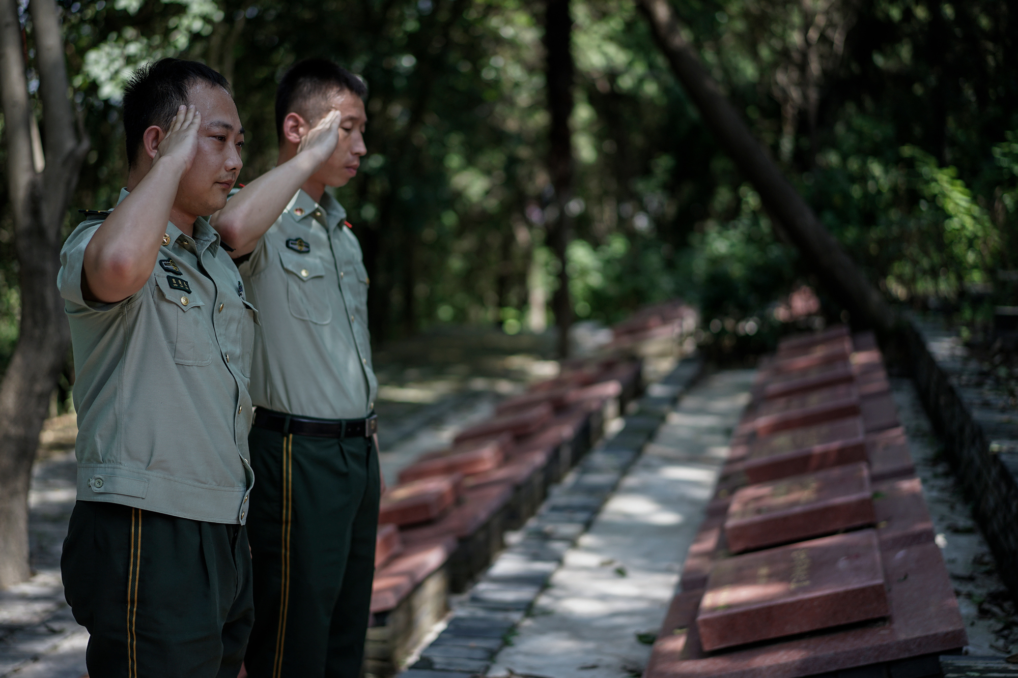 Ti’s fellow firefighters salute his grave, at Martyrs’ Cemetery in Suizhou, August 10, 2017. 