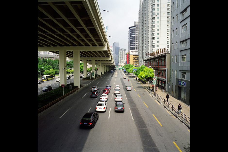A shadow falls across West Yan’an Road, below, from the Yan’an Elevated Expressway. The municipality of Shanghai completed the construction of the expressway, which soars directly above the major thoroughfare of Yan’an Road, just four years after breaking ground in 1995. Although the elevated expressway connects with the existing road infrastructure, some residents complain that the expressway has deepened the isolation and invisibility of these neighborhoods.
