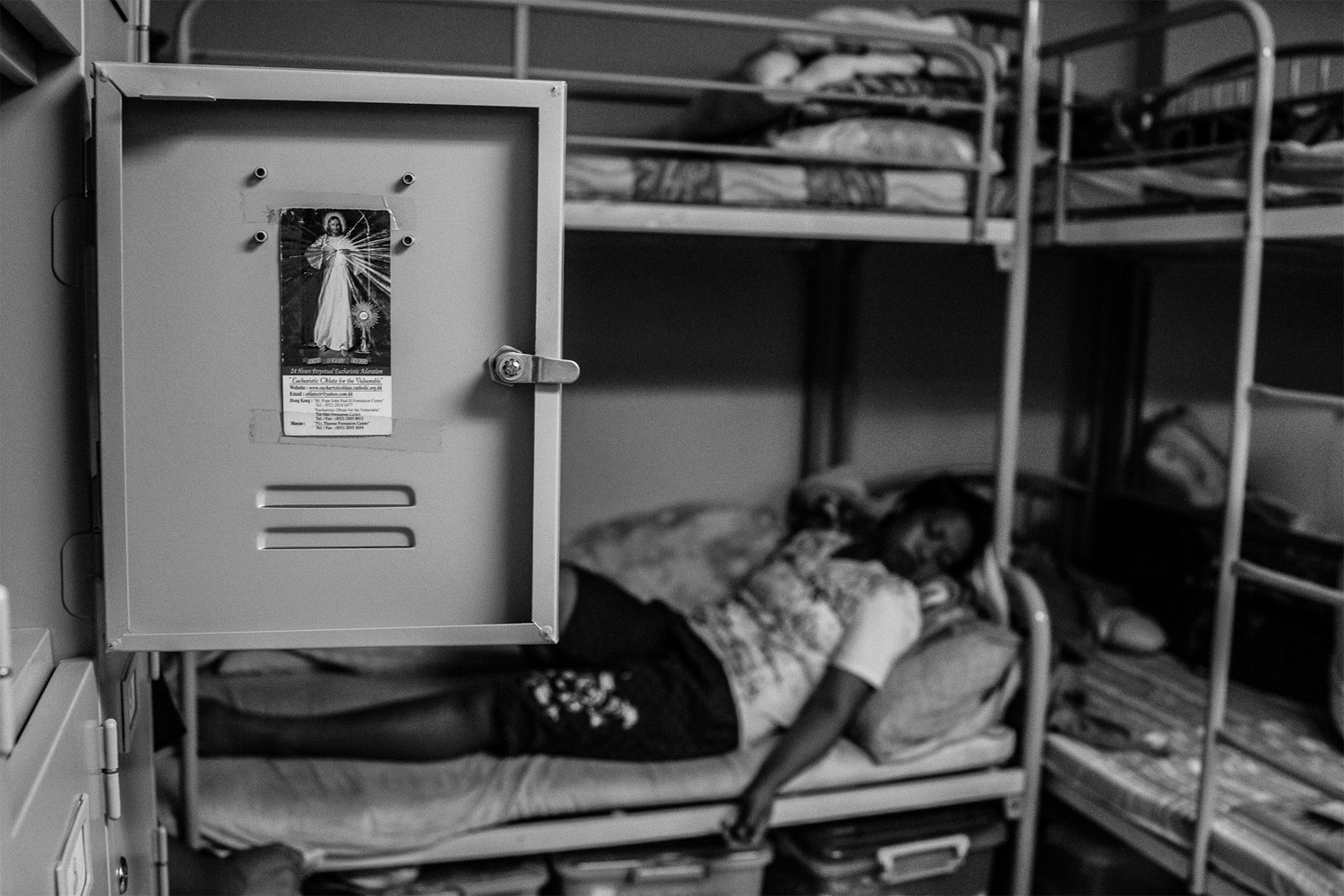 An image of Jesus Christ adorns a resident’s locker as Sunarwi, an Indonesian domestic worker, rests after spending a day in court. She was accused of stealing 150 Canadian dollars from her former employer. Following a trial, a court later found Sunarwi guilty and sentenced her to a three-month prison term. Once foreign domestic workers have been sentenced and served out their jail terms, they are often deported and barred from returning to Hong Kong.