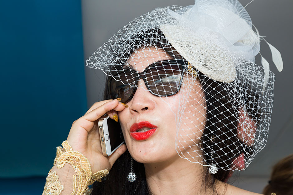 Siyu Yang talks on her gold-cased iPhone that matches both her gold dress and the Comte De Mazeray champagne infused with 24-karat gold flakes she hawked at the most exclusive yacht parties.