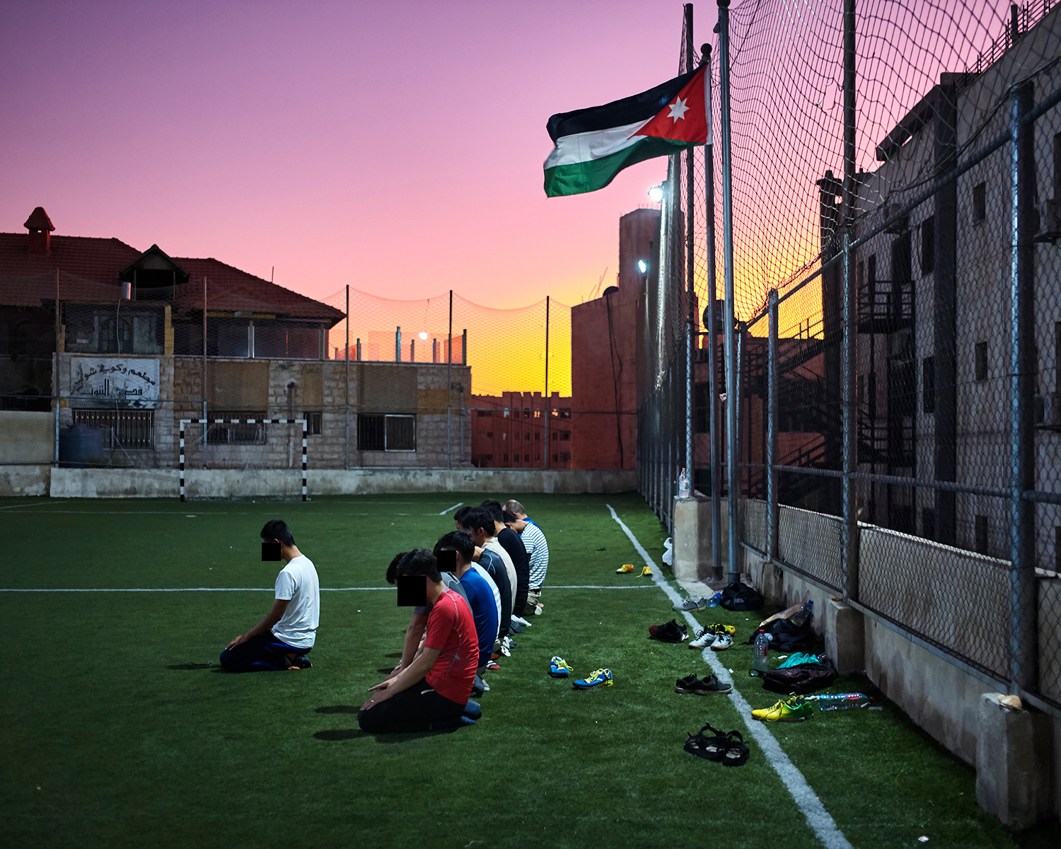Umar and other Chinese Muslim students pray on a soccer field during a game, in Amman, September 2017.