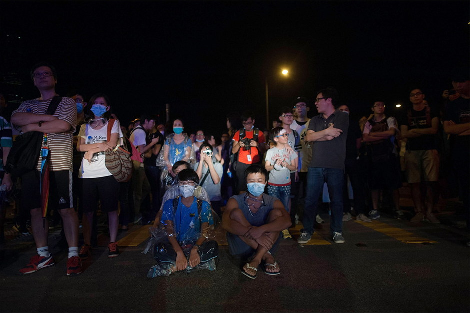 Protesters sit on a street during a pro-democracy protest. (Photo by Anthony Kwan/Getty Images)
