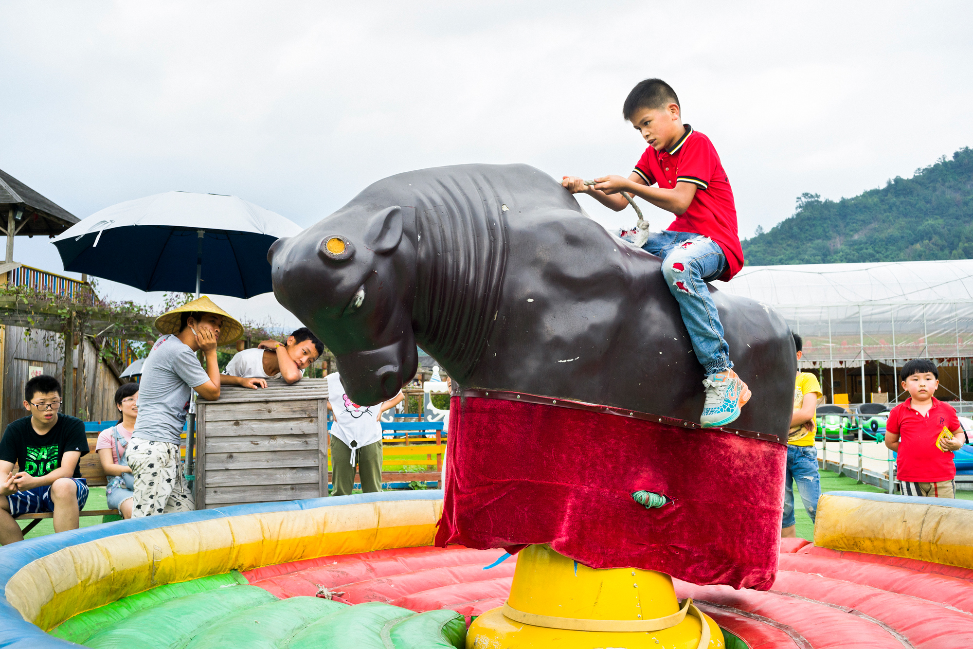 A child rides a mechanical bull at a leisure farm, a type of resort, in Huling township, October 3, 2016. 