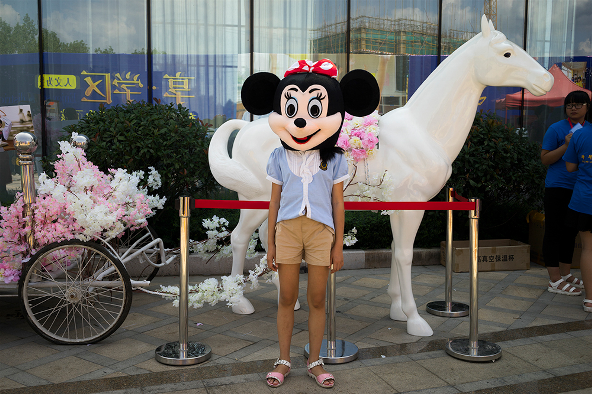 A child wears a Minnie Mouse costume for a photo in Mayu township, October 3, 2016. A real-estate sales center set out the cartoon objects and costumes to attract customers.