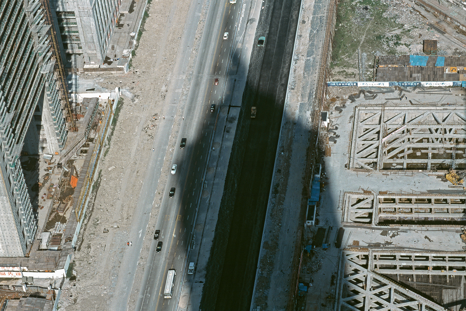The shadow of the Jin Mao Tower falls across Century Boulevard and other construction sites in Lujiazui, 1999.