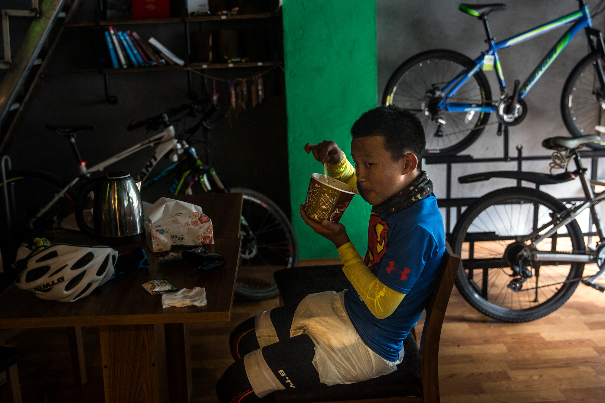 Runxi eats instant noodles in Luding county, Garze, Sichuan, July 18. Because restaurants and food in general are scarce along their route, Runxi and Chao eat a lot of instant noodles, and have them at least 15 times over the course of the 23-day trip.