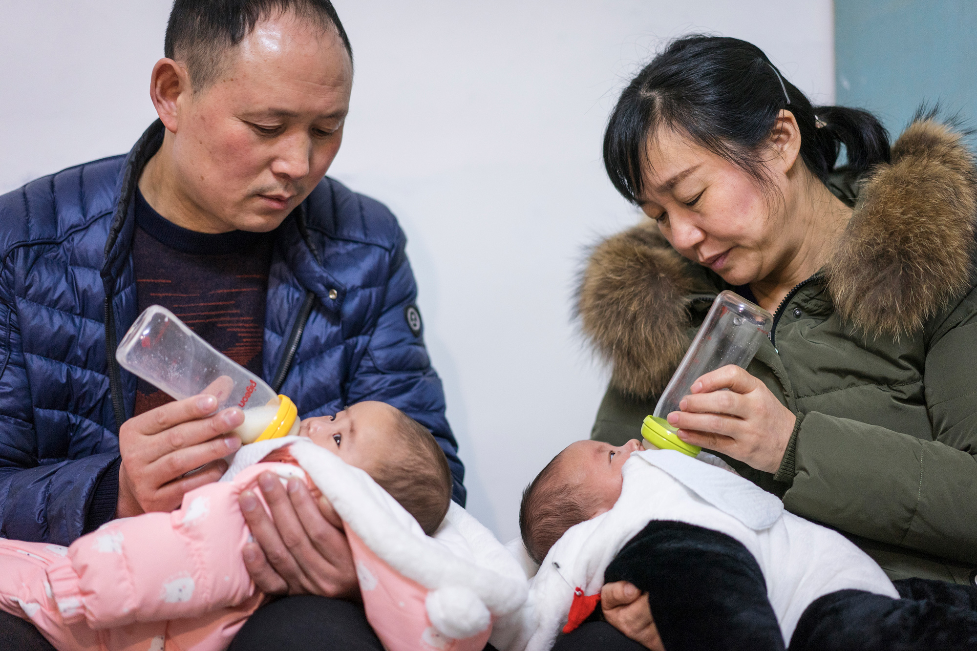 Zhiying and Fangguo feed the twins at home, in Suizhou, March 2, 2018. “The way to take care of babies is so different from when Ti was young. It’s hard for us to keep up with the times,” Fangguo says. 