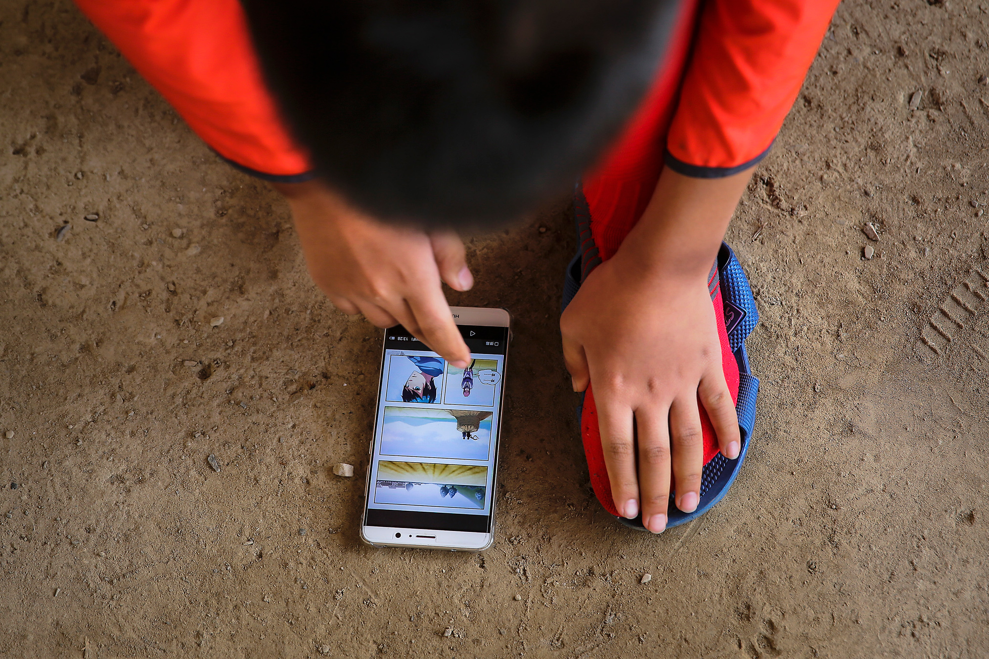 Runxi reads a cartoon on his phone, July 28. Chao urges Runxi not to spend too much time on his phone during the trip to make sure that the boy gets enough rest. When they arrive in Lhasa, Runxi says, “I can finally play games.”