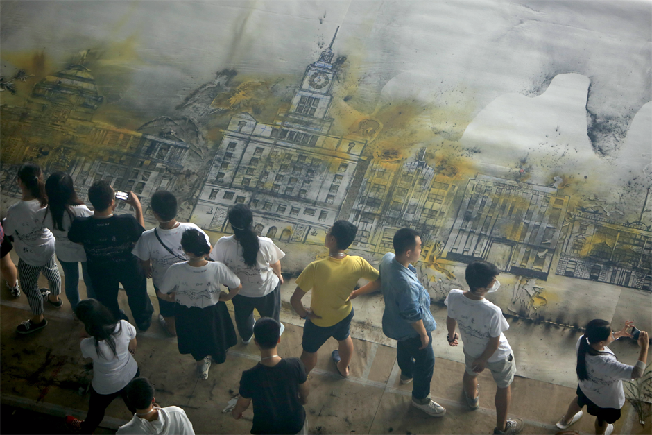 Visitors look at a piece by Cai, created by gunpowder, at the Museum of Contemporary Art, Shanghai, July 24, 2014.  (ChinaFotoPress photo)