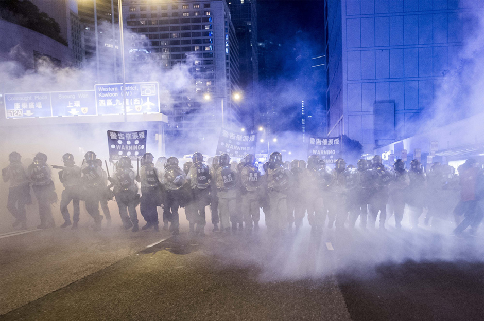 Police officers stand in a cloud of tear gas. (Photo by Xaume Olleros /AFP/Getty Images)
