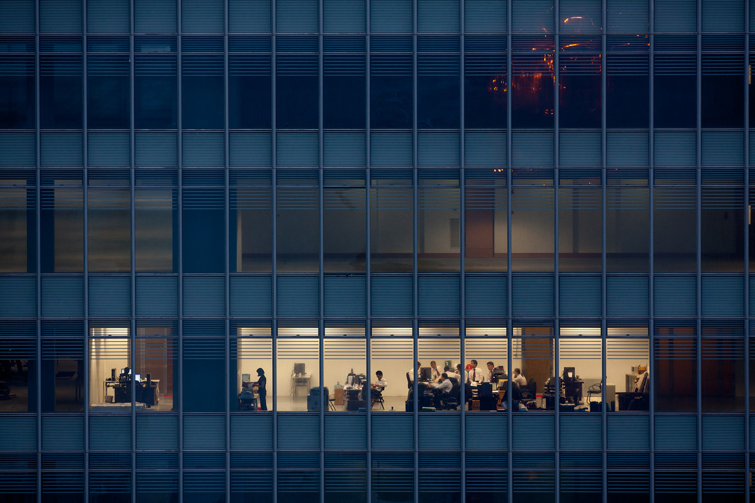 Office workers, perhaps the leasing department for the vacant building, are the only occupants in a newly constructed tower in Lujiazhui, 2010.