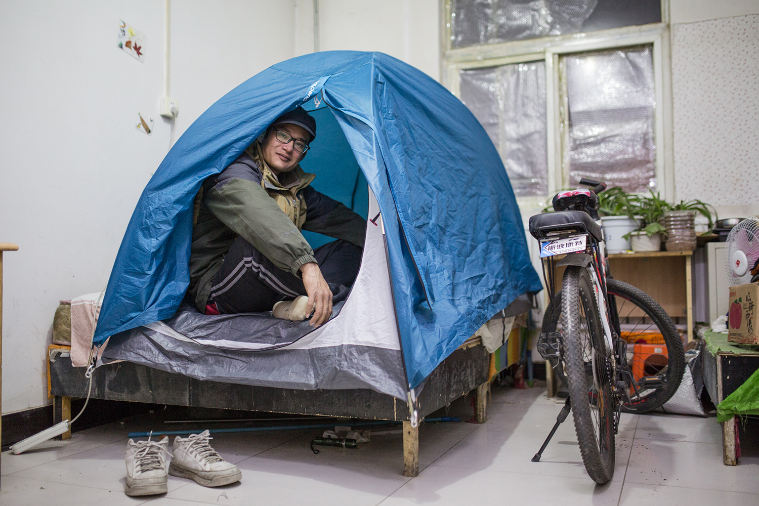 November 18, 30-year-old Xu Qinsheng stays in a tent on his bed to keep warm, in Banbi village, Beijing. He has lived here for four years. But the building hasn’t installed heating yet because of new prohibitions on the burning of coal. As China tries to tackle air pollution by using cleaner fuel, shortages of natural gas leave some places without heat amid freezing winter temperatures. (Zhou Na)