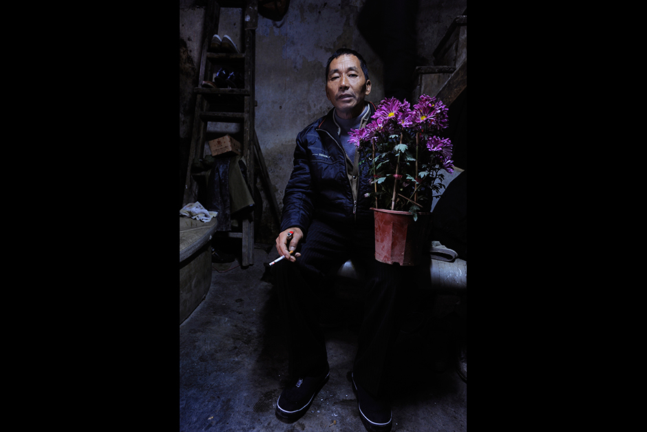 A Wuwucun man shows a pot of flowers he has salvaged from a  department store’s discarded holiday decorations.
