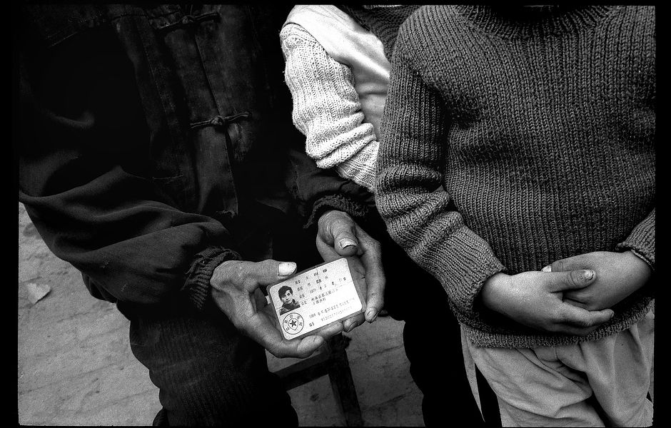 Wang Dage’s father and children stand next to his ID card. Approximately 100-120 million Chinese are infected with the hepatitis B virus, yet due to a lack of resources and the social stigma that has been associated with the disease, people are unaware of the severe public health risk it poses. Henan, China