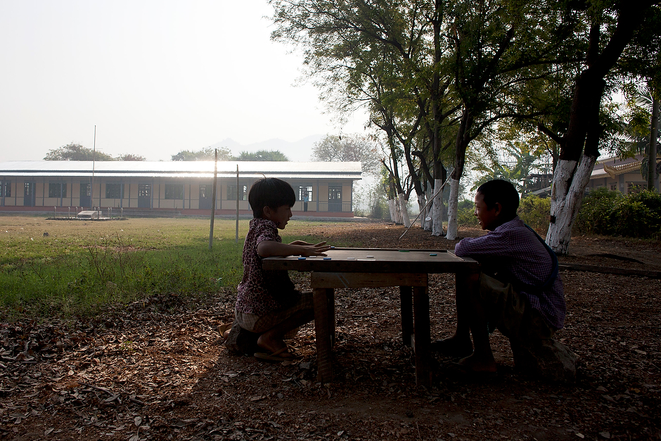 Children share a laugh and a board game in the shade near a new school built with funds from the China National Petroleum Corporation (CNPC) in a village northeast of Mandalay. CNPC is building an oil and gas pipeline from Myanmar to China and has made donations like this school throughout the country—a sign, say observers, that China’s state companies are trying to win local goodwill.