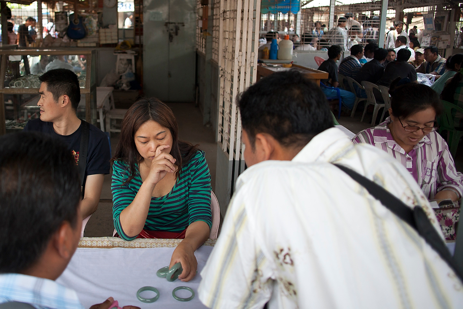 A trader from Kunming in Southwest China looks over bangles, rings, and earrings at a jade market. The Chinese  trade in jade and gems from Myanmar, taking the stones back across the border to sell for a profit in China.