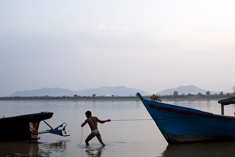 A man hauls his boat from the shore in the early morning in Myitkyina, the capital of Kachin State. If the Chinese-financed Myitsone dam project is ever completed, this area—some 120 square miles—will be flooded.