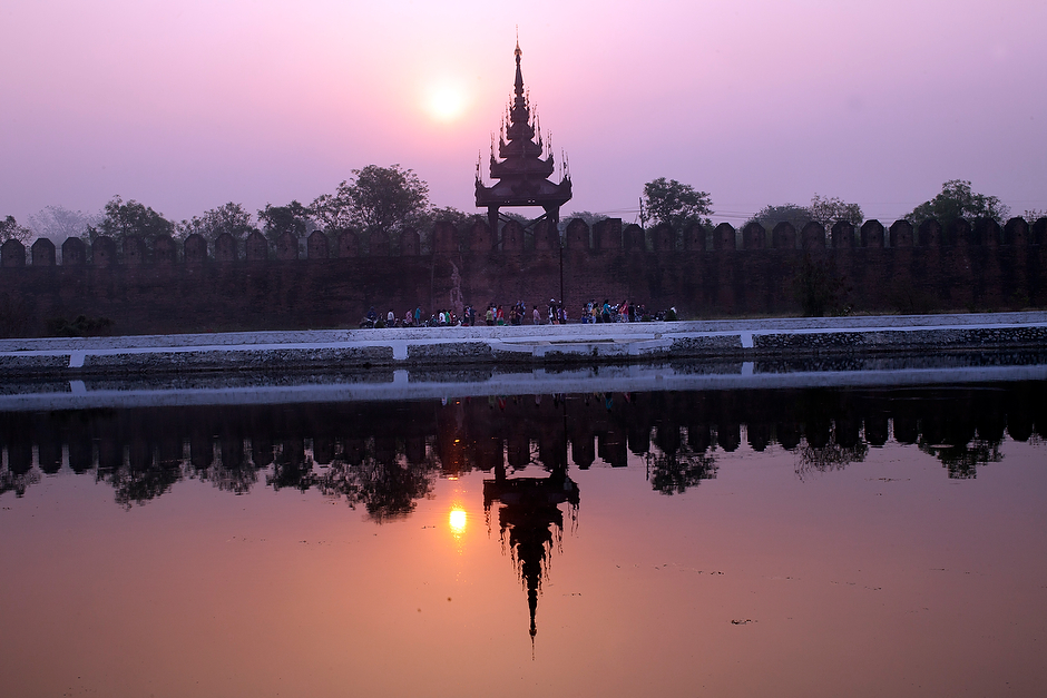 A group of Chinese exercise to music early in the morning by the moat of Mandalay Palace.