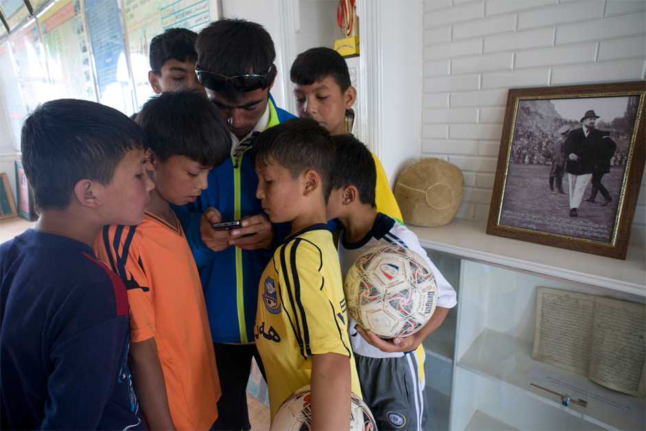 A hand-sewn sheepskin soccer ball commemorating the villagers’ victory over the British and Swedish teams in 1927 is on display in a museum at Iksak Elementary School. Coach Ekber, born and raised in a town with a rich soccer history, shares a photograph on his cellphone of his grandfather playing soccer when he was young.