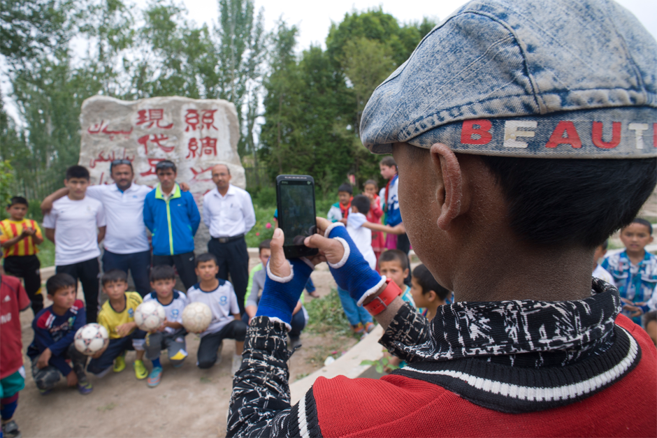 A stone monument in front of Iksak Elementary School reads: “Birthplace of Modern Soccer on the Silk Road.”