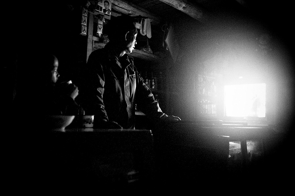 Television arrived in the Mosuo village of Aguwa some ten years ago and has changed sleeping habits ever since. The shopkeeper is a Han Chinese who married into a Mosuo family. Aguwa, Yunnan, China.