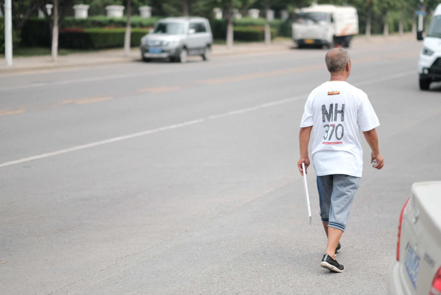 A relative of a passenger on the missing Malaysia Airlines Flight MH370 walks on the street before a press conference held by the Malaysian investigation team, in Beijing, August 3. In May, the last search effort for the flight that went missing four years ago ended without any new findings. (ImagineChina)