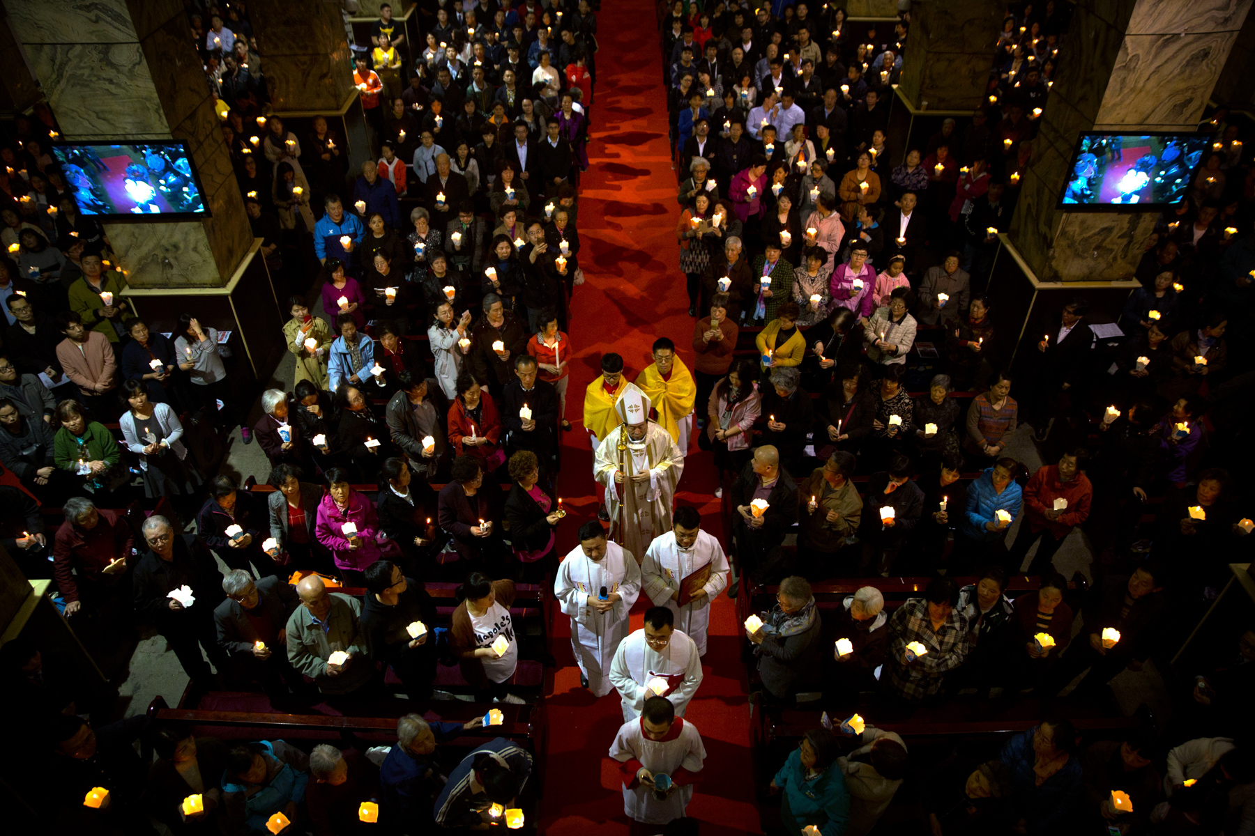 Chinese Bishop Joseph Li Shan, center, walks down the aisle during a Holy Saturday mass on the evening before Easter at the Cathedral of the Immaculate Conception, a government-sanctioned Catholic church in Beijing, March 31. In September, the Vatican signed a controversial deal with China acknowledging the Chinese Communist Party’s power to nominate bishops. Meanwhile, the government ramped up its policing of “unauthorized” Protestant churches. (Mark Schiefelbein/AP Photo)