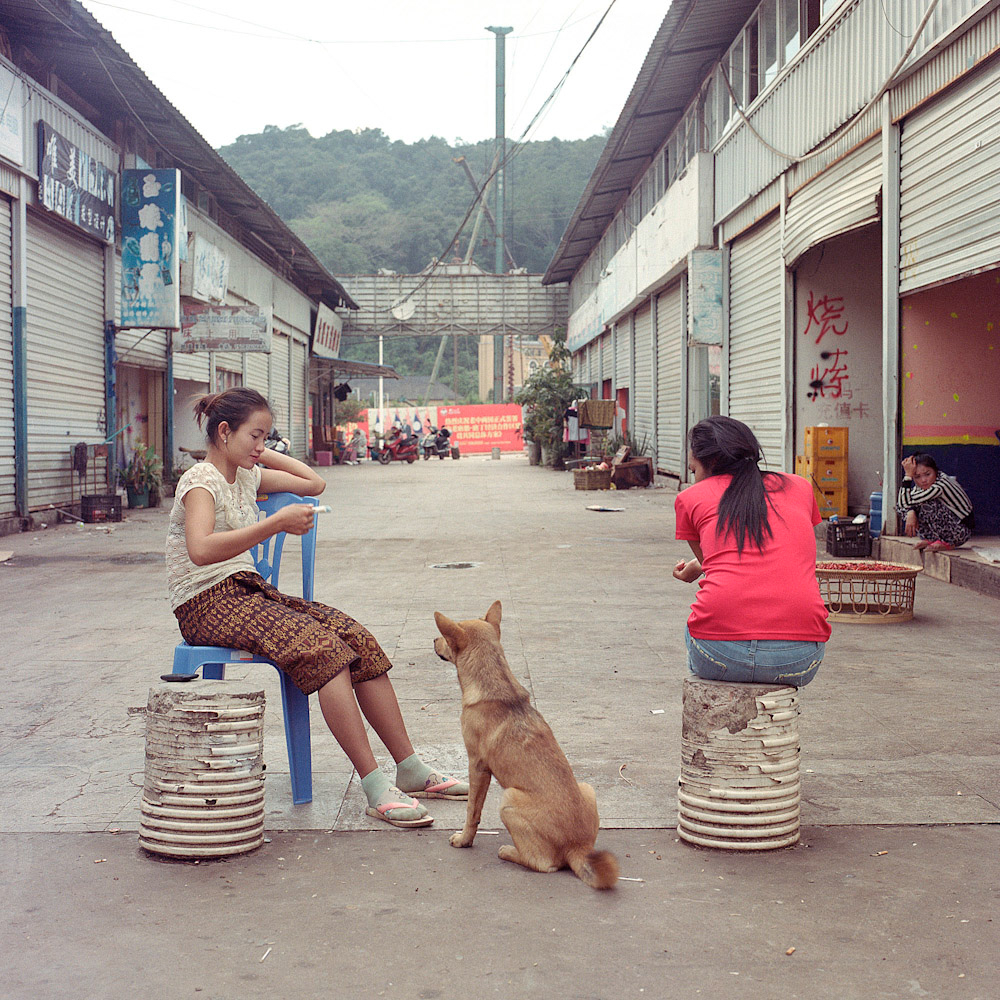 Lao workers wait for customers outside a restaurant, January 2016.