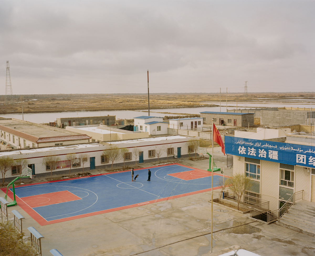 Police officers train a police dog next to a police station in Qiemo county in southern Xinjiang, December 2016.