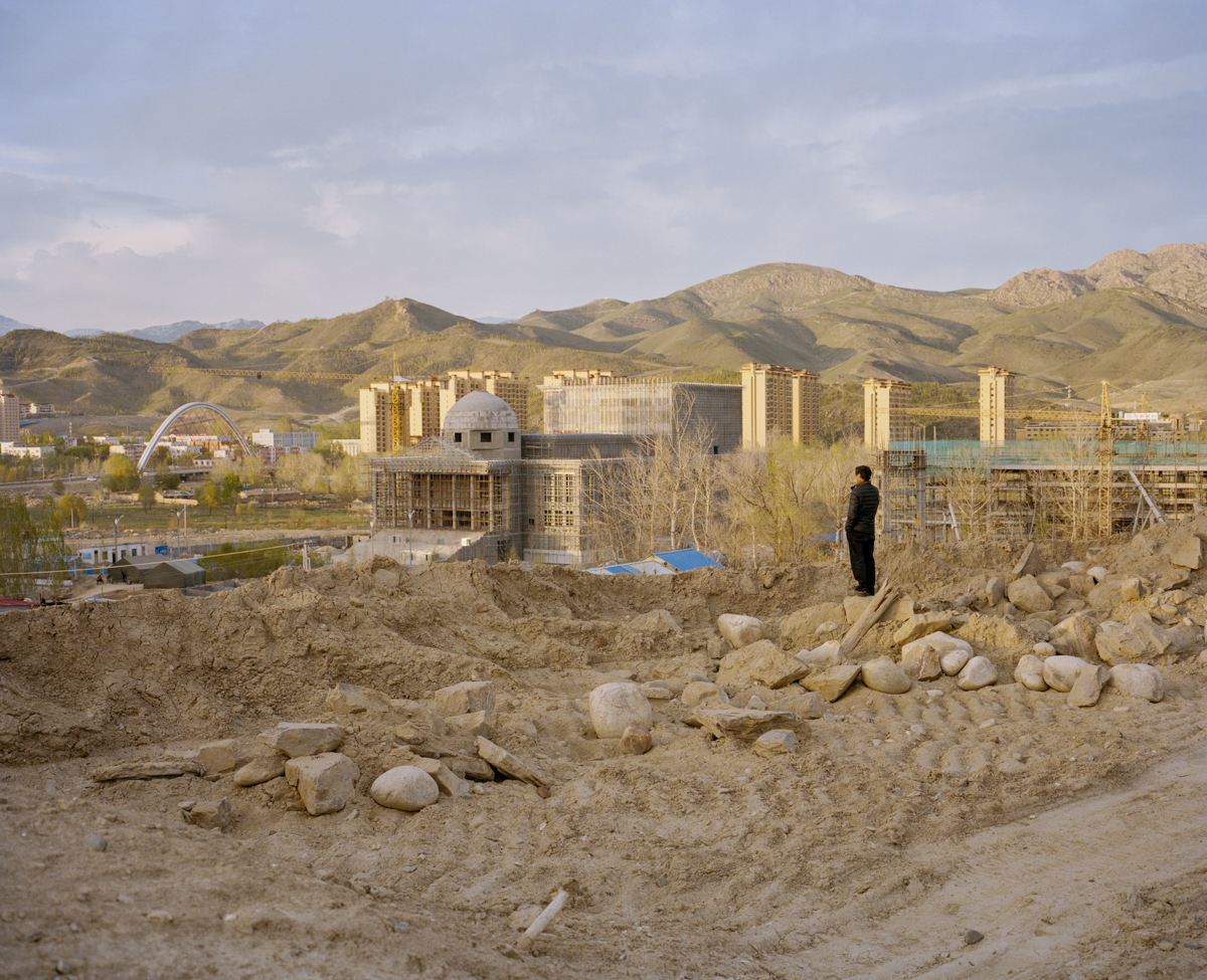 A Han migrant worker from eastern China makes a phone call above a construction site in Altay city, in Ili Kazakh Autonomous Prefecture, in far northern Xinjiang, May 2017.