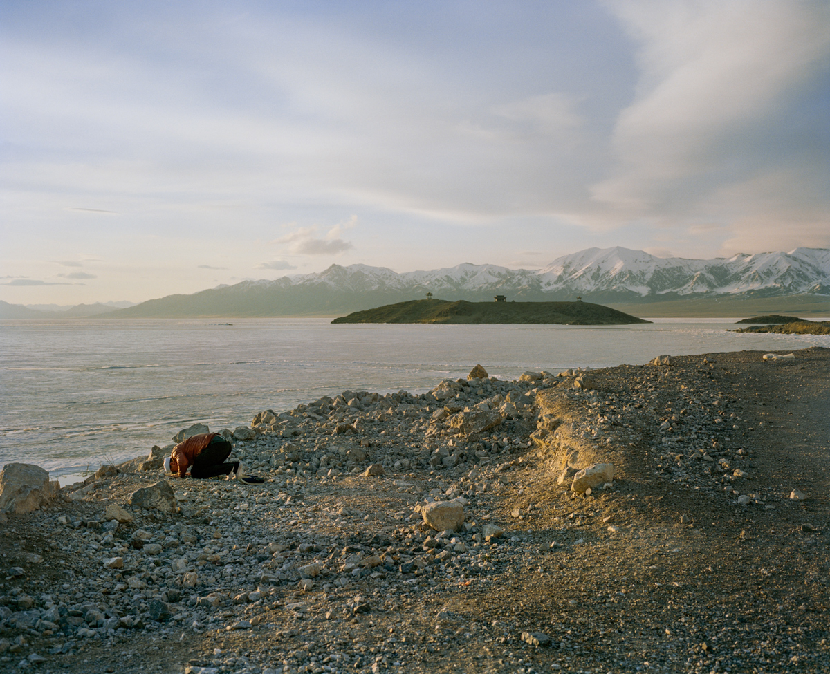 A Muslim man prays at sunset on the shore of Saytam Lake, near the Kazakhstan border, May 2017.